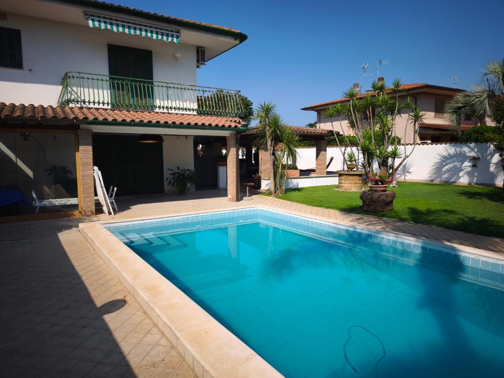 a swimming pool in front of a house at La casetta di Daniela in Sabaudia
