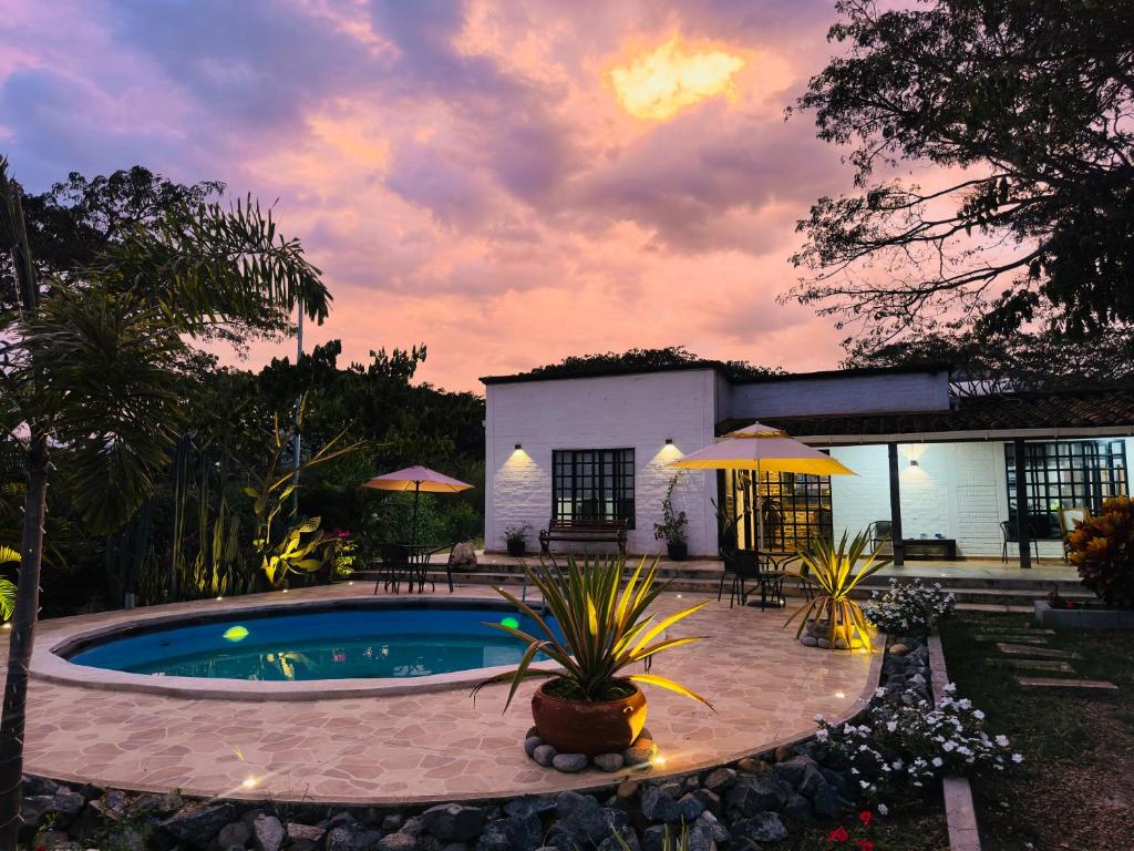 a backyard with a swimming pool and a house at Finca el origen in Roldanillo