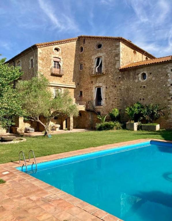 a house with a swimming pool in front of a building at Can Traver de Besalú in Maia de Montcal