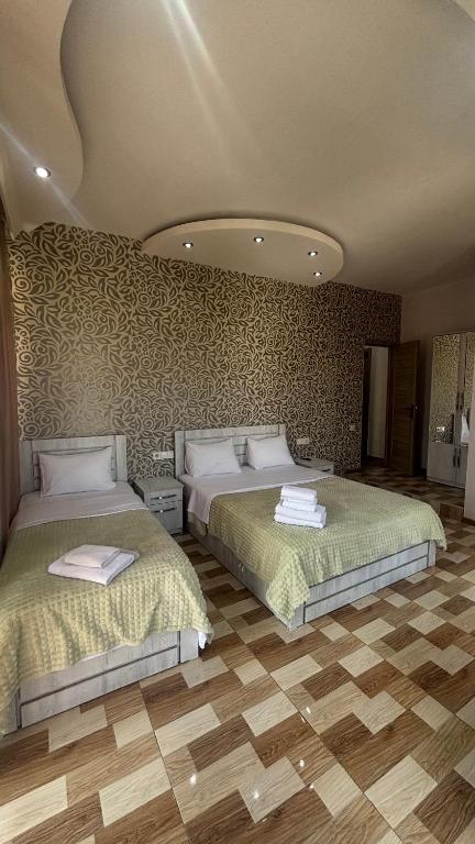 a bedroom with two beds in a room at Hotel New Royal in Tbilisi City