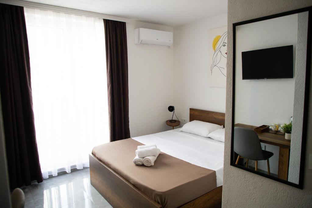 a hotel room with a bed and a mirror at Nuvelle Boutique Hotel in Prizren