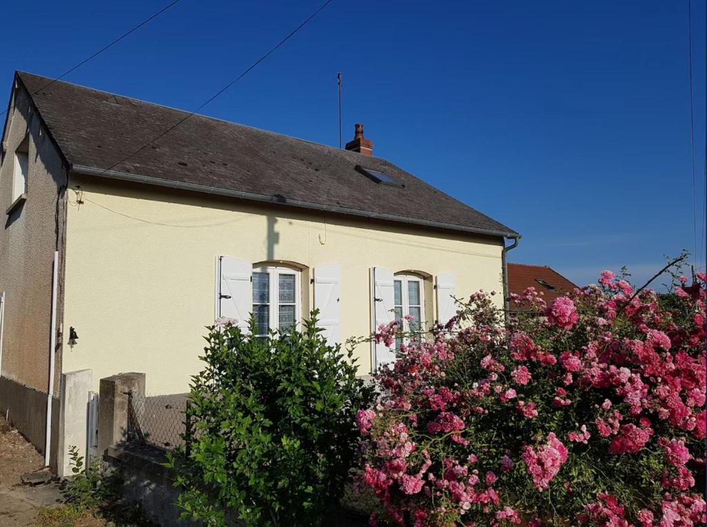 a white house with pink flowers in front of it at La Maison Rose in Mhère