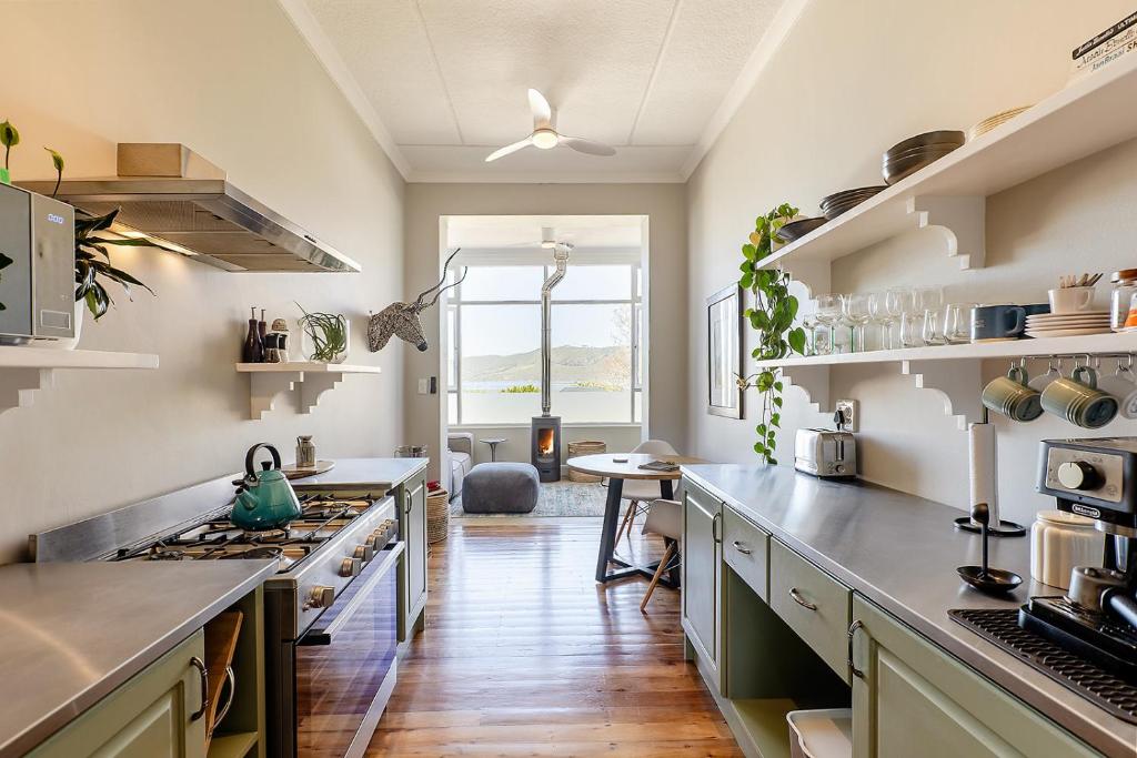 a kitchen with stainless steel appliances and wooden floors at Lagoon View Cottage in Knysna