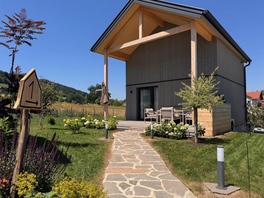 a building with a table and chairs in a garden at Die Tinys - Ferienhäuser am Attersee in Nussdorf am Attersee