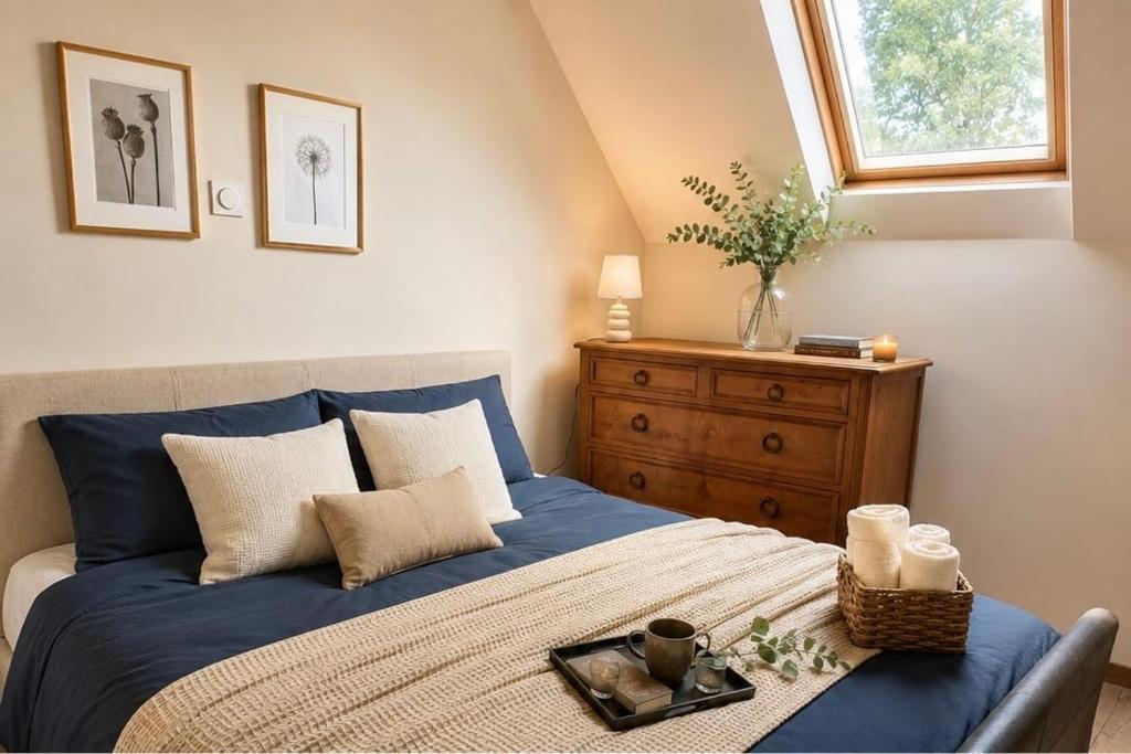 a bedroom with a blue bed with a wooden dresser at Le Noble Jardin in Mohon