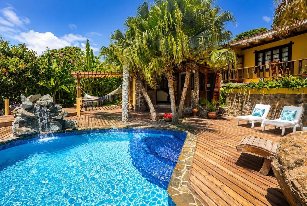 a backyard with a swimming pool and a wooden deck at 3 Bedroom Villa with Pool and Ocean Views in Cap Estate