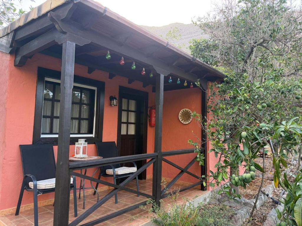 a house with a table and chairs on a deck at Finca Nim 1 in Mogán