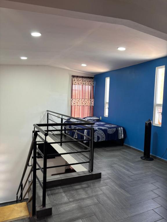 a bedroom with a bed and a blue wall at Tiny House Molino Alto in Ciudad Fernández