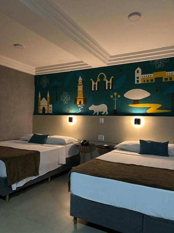 a bedroom with two beds and a mural on the wall at Terrazas Hotel in Curitiba