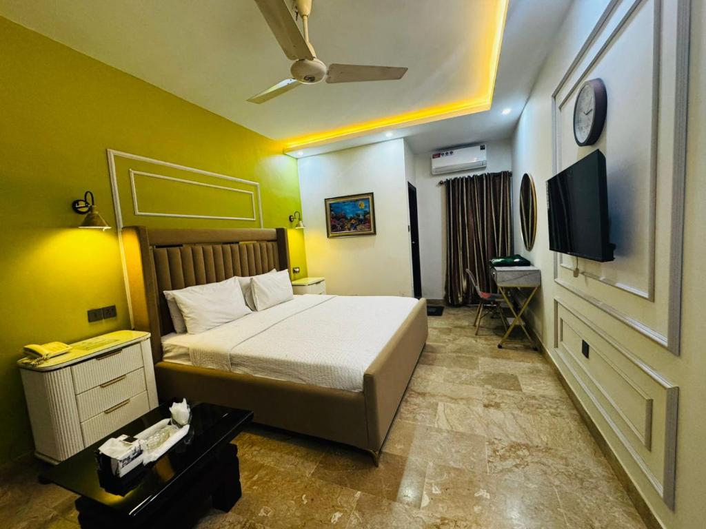 a bedroom with a bed and a flat screen tv at Seaview Lodge Guest House in Karachi