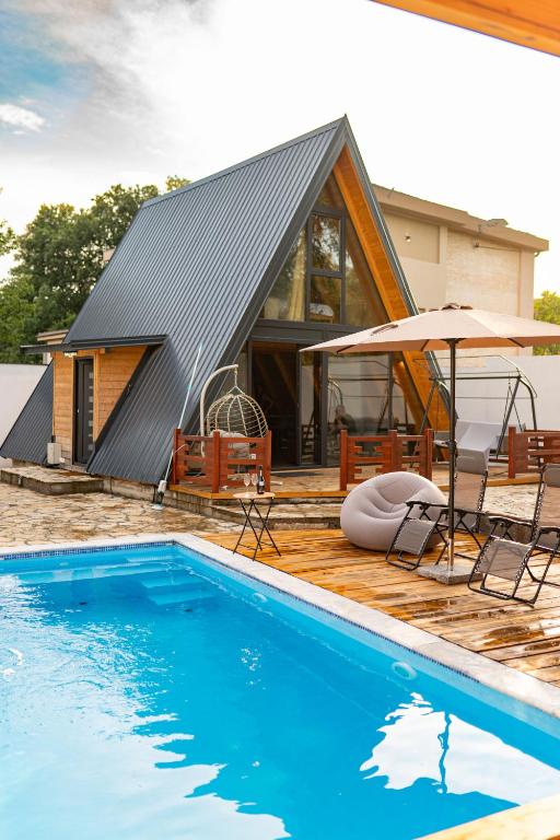 ein Haus mit Swimmingpool neben einem Haus in der Unterkunft Vila Markizo in Barajevo