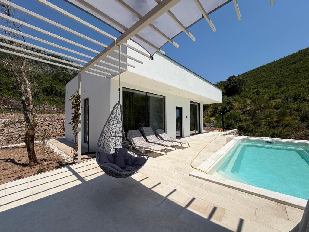 a patio with a swing and a swimming pool at Green House in Perazića Do