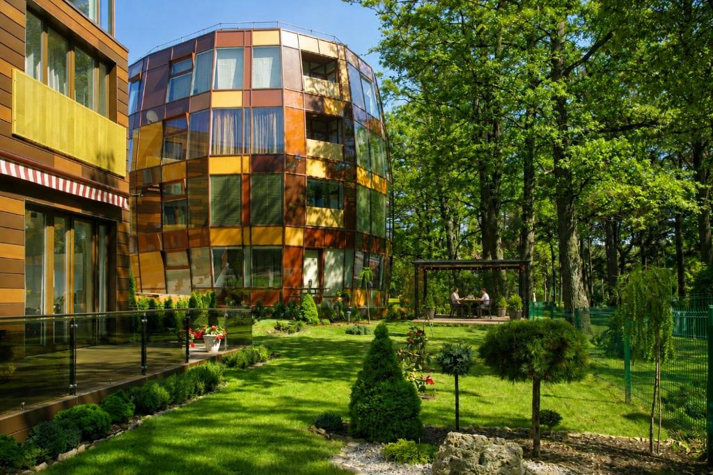 a building with a garden in front of a building at Apartamentai Palangoje Arune in Palanga