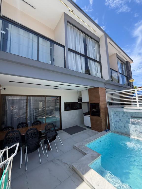 a house with a patio and a swimming pool at Flat do Lucca 02 - Piscina - 50m da Praia - Até 10 Pessoas in Tamandaré