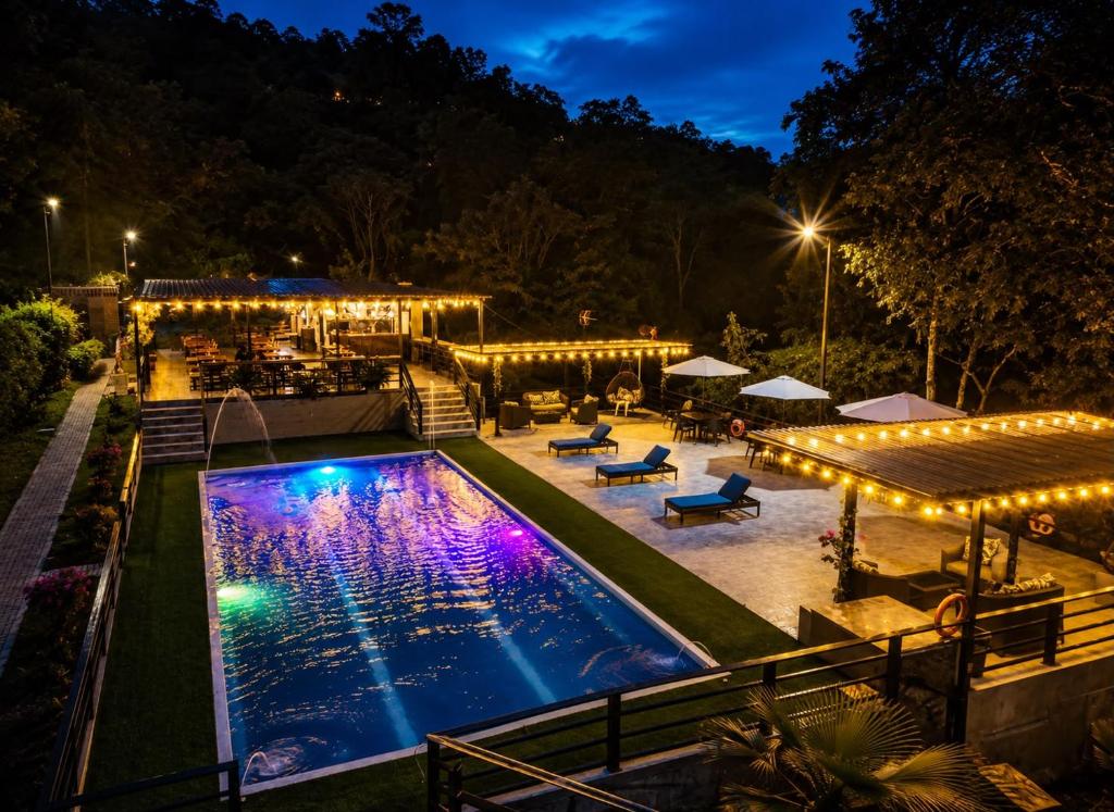 a pool at night with lights and a patio at Hotel Zipa Villeta - Sede Campestre in Villeta