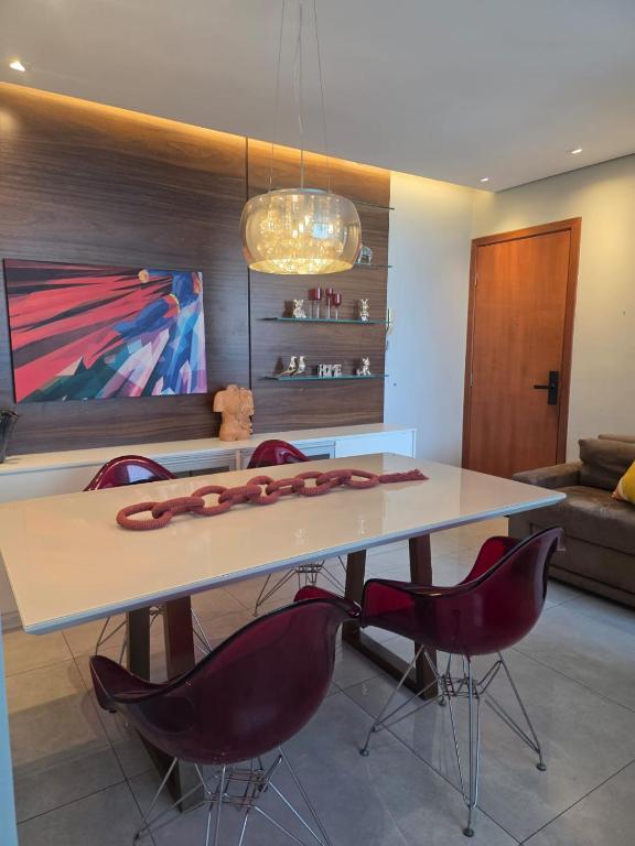 a dining room with a table and some chairs at Apartamento 2 Quartos Moderno in Belo Horizonte