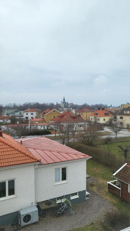 a white house with a red roof in a town at Sommarlägenhet i Vadstena in Vadstena