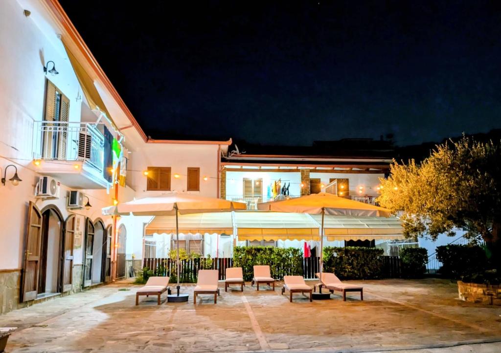 a patio with chairs and umbrellas in front of a building at Tenuta Marga in Agnone