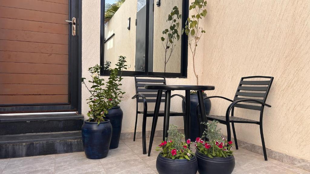 three blue vases with flowers and a table and chairs at وحده خاصة بمدخل مباشر s1 in Al Kharj