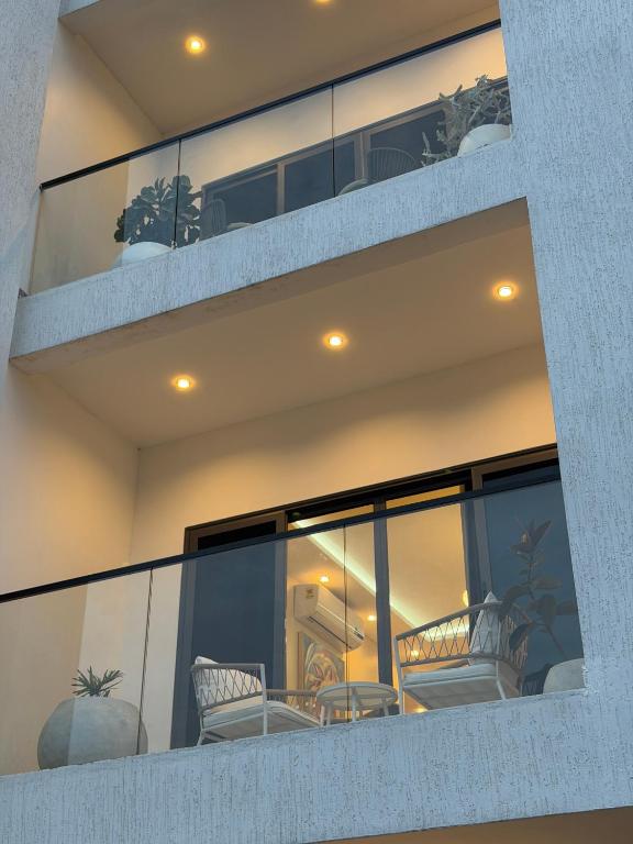 a balcony with chairs and plants on a building at Bellagio Two Bedroom with Balcony in Kwedonu