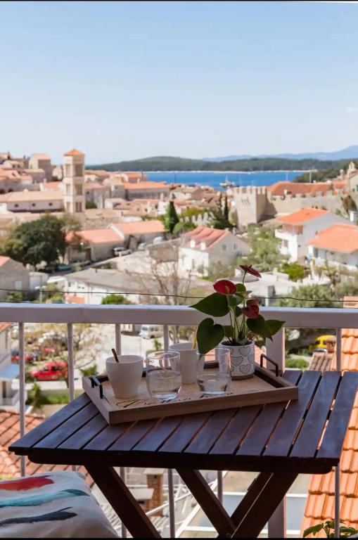 a wooden table with flowers on top of a balcony at Guest House Vuljan in Hvar