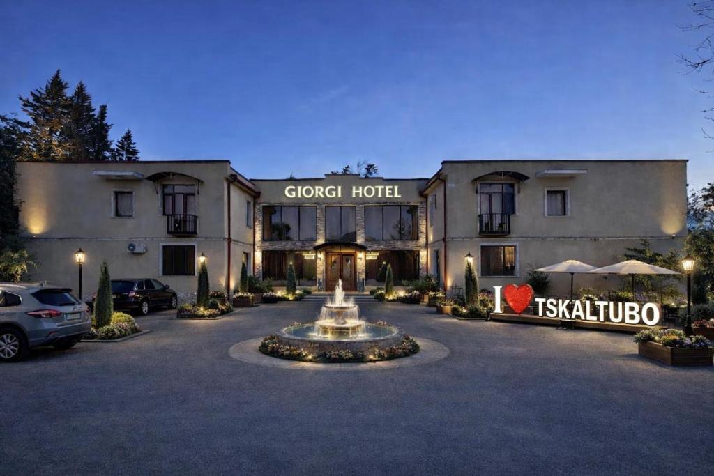 a hotel with a fountain in front of a building at Hotel Giorgi in Tsqaltubo