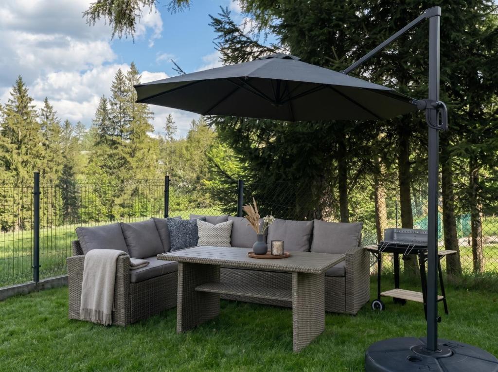 an umbrella over a couch and a table at Villa Taternik - Studio Apartment - Mountain View in Zakopane