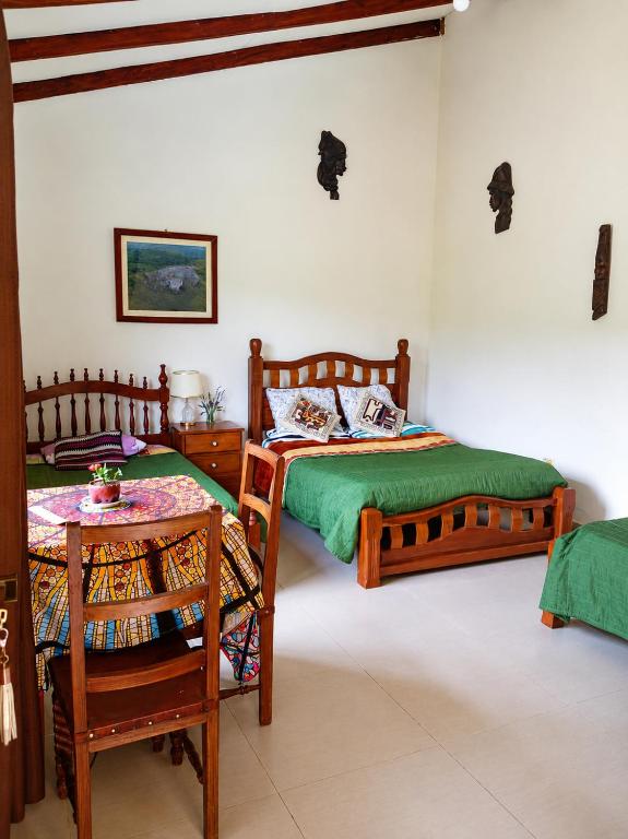 a bedroom with two twin beds and a table at Looking Samaipata Habitación Doble in Samaipata
