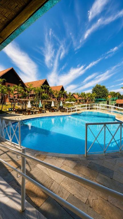 a swimming pool at a resort with a fence at Hotel Gran Minas in Vespasiano