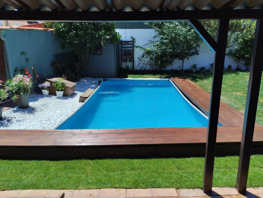 a swimming pool in a yard with a wooden deck at Casa Alicia in Poio