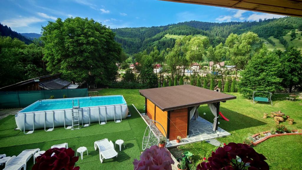 a backyard with a swimming pool and a house at Serbeca in Broşteni