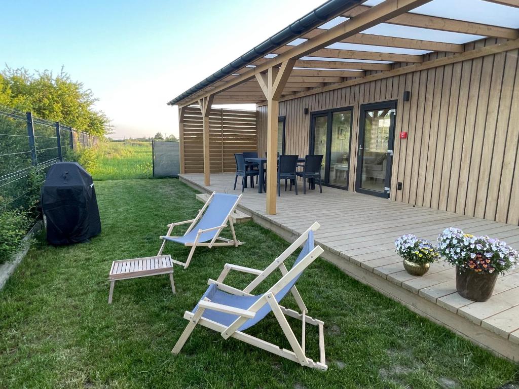 two chairs and a table and chairs on a deck at Aura Baltic in Rewal