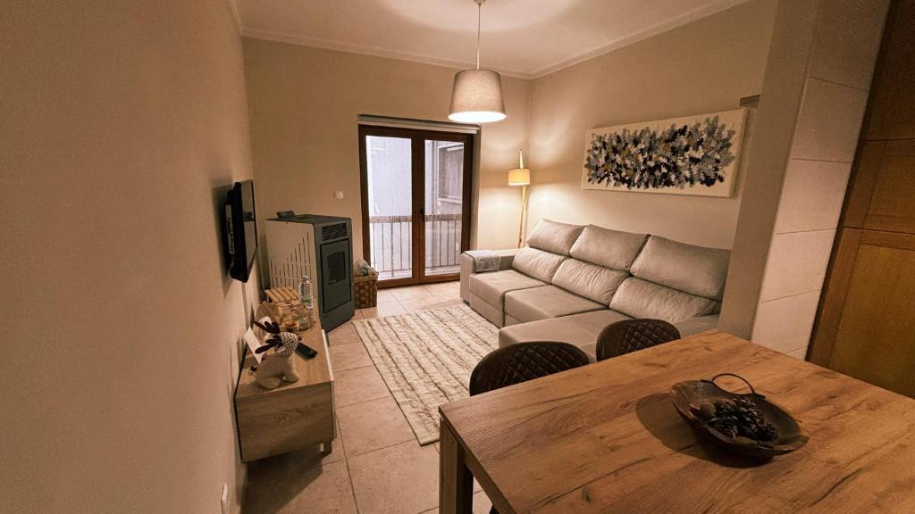 a living room with a table and a couch at Casa da Serra - T1 - Penhas da Saúde in Penhas da Saúde