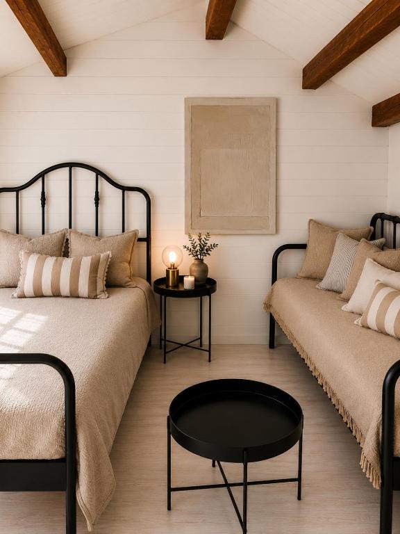 a bedroom with two beds and a coffee table at Baltic Beach Cozy Tiny House B in Pērkone
