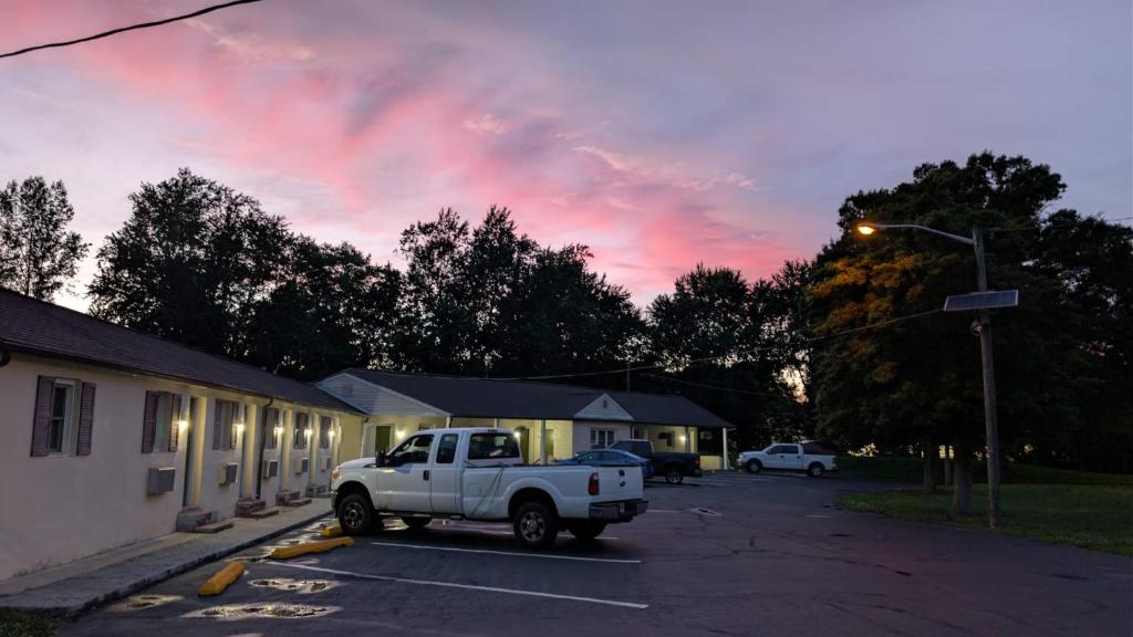 a white truck parked in a parking lot next to a building at Red Lion Motel Southampton in Southampton