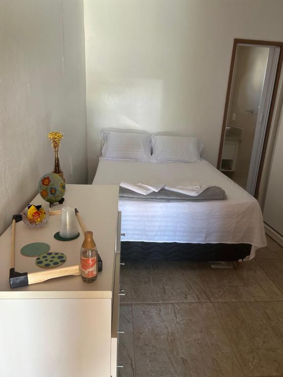 a bedroom with a bed and a table with a counter at Suite LUAR in Saquarema