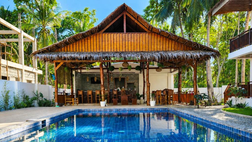 a pavilion with a swimming pool in front of a house at Jungle Vibes Hostel in San Juan