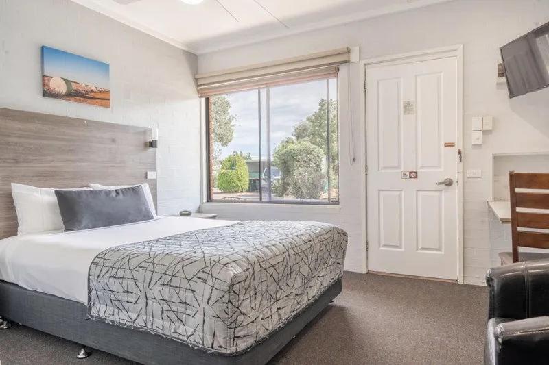 a bedroom with a bed and a large window at Nicholas Royal Motel - Hay CBD in Hay