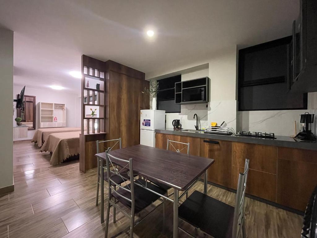 a kitchen and living room with a table and chairs at Olive Loft - Local Sensory and Boutique Experience in Tacna
