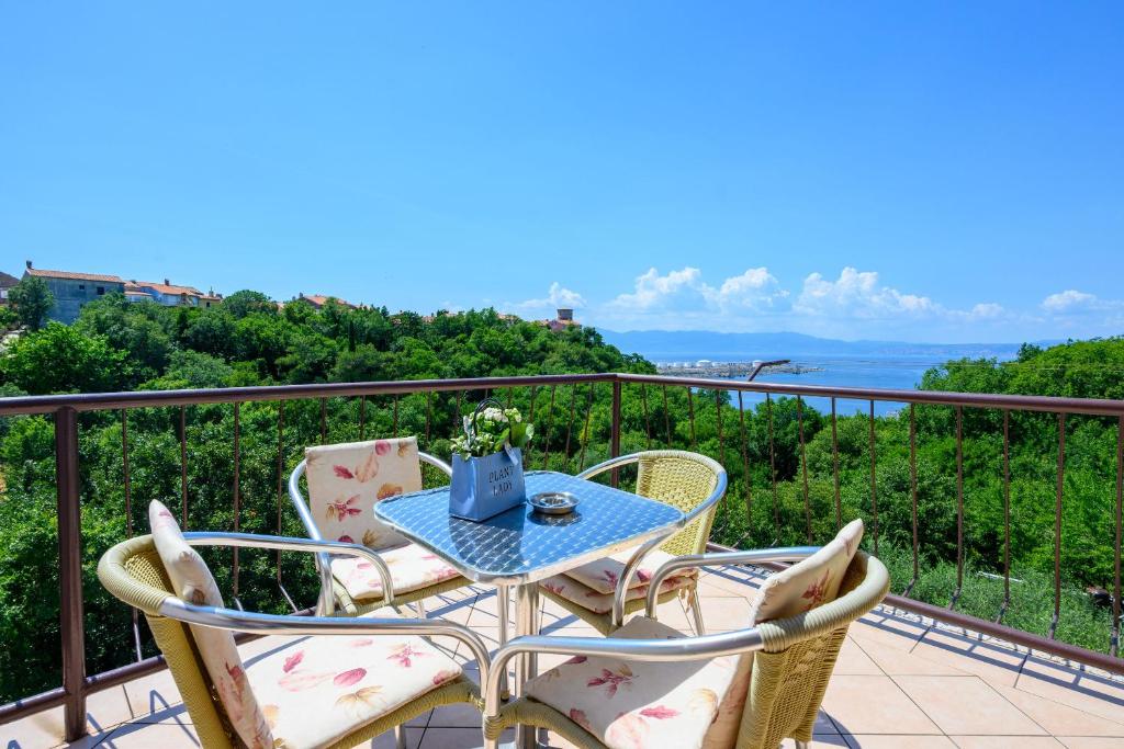 a table and chairs on a balcony with a view of the ocean at Room Marta in Omišalj