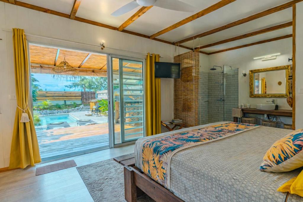 a bedroom with a bed and a large window at Breeze Ocean Bungalow Moorea in Moorea