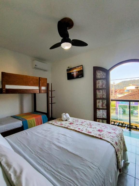 a bedroom with two beds and a ceiling fan at Pousada Alecrim Dourado in Paraty