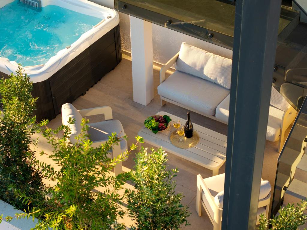 a balcony with a pool and a chair and a tub at Maslina Residence - Hvar in Hvar