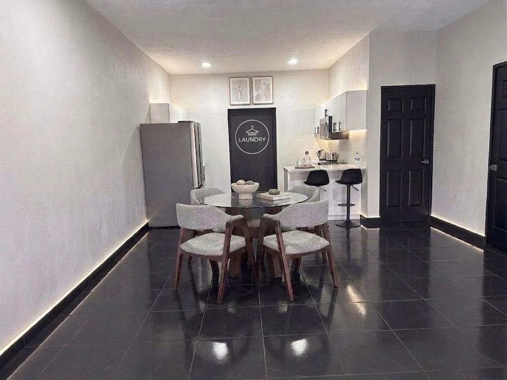a dining room with a table and chairs and a kitchen at TinyHouseMX1 Comodidad y playa que se disfruta in San Patricio Melaque