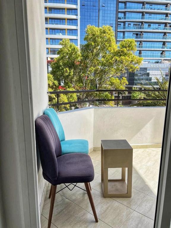 a blue chair and a table on a balcony at la corniche de tanger in Tangier