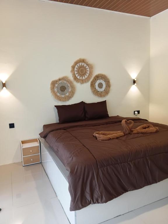 a bedroom with a bed with two mirrors on the wall at VIA Homestay 1 in Kuta Lombok