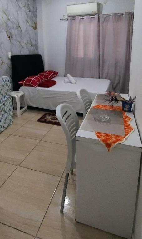 a room with a bed and a table and chairs at Kitnet na Imbiribeira in Recife