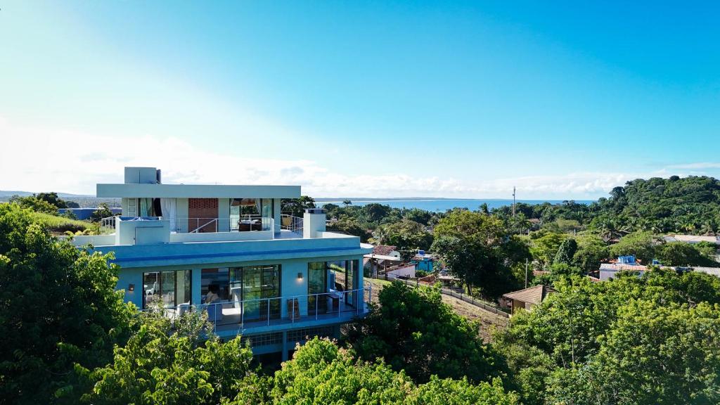 a blue house on top of a hill with trees at Casa Luar da Sereia - Itacaré in Itacaré