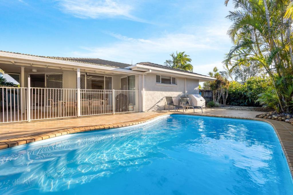 a swimming pool in front of a house at Skippers Place in Noosaville