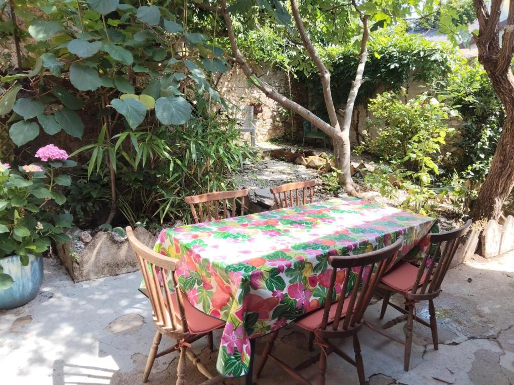 a table with chairs and a table cloth on it at Maison Berrichonne 2 chambres cour et jardin in Saint-Marcel